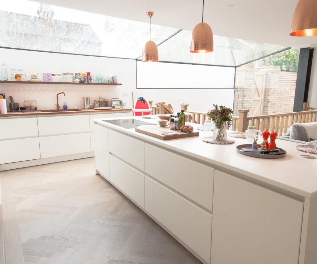A German kitchen with white handleless kitchen units and a cooking island