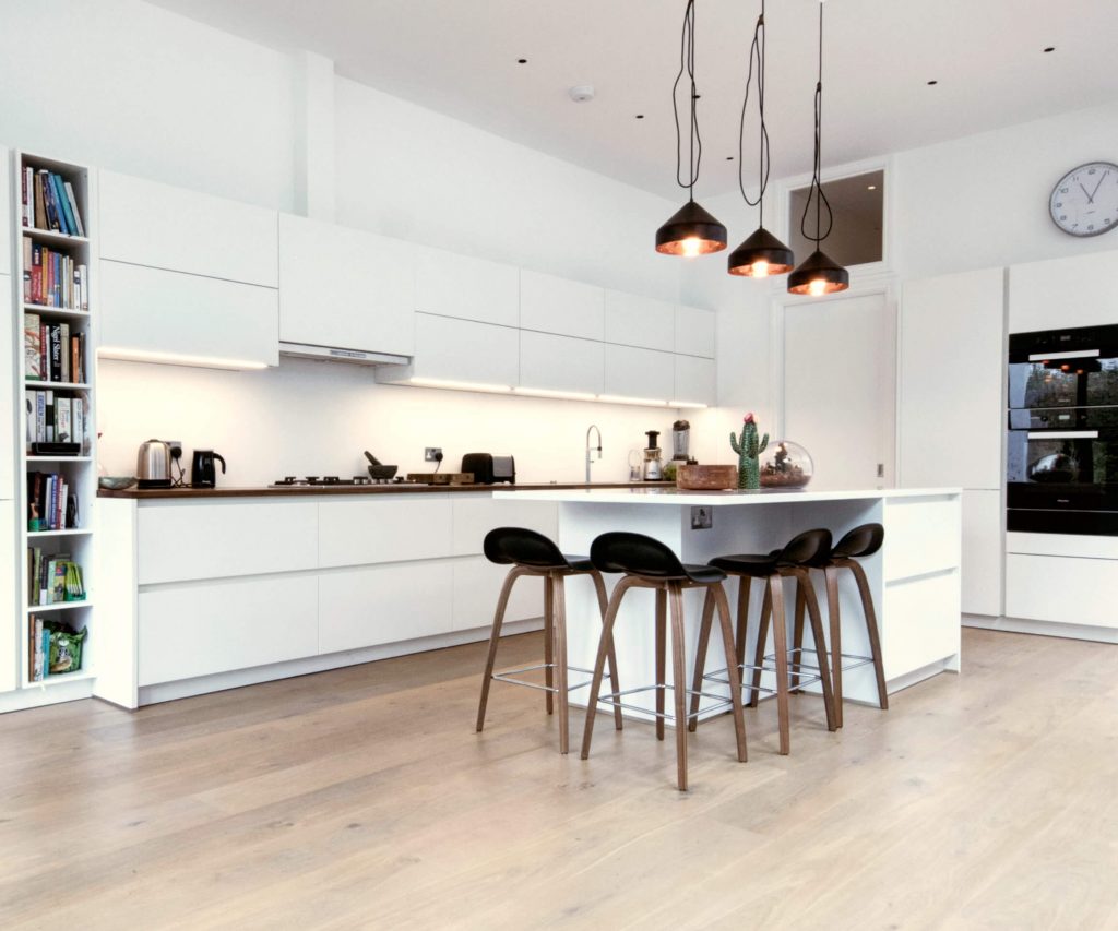 A German kitchen with matt white handleless kitchen units and a kitchen island