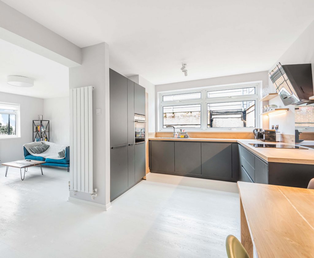 A black German kitchen with handless kitchen units in a modern flat