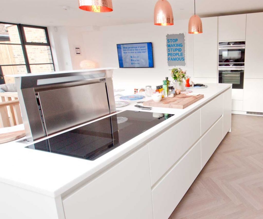 A German kitchen with white handleless kitchen units and a cooking island