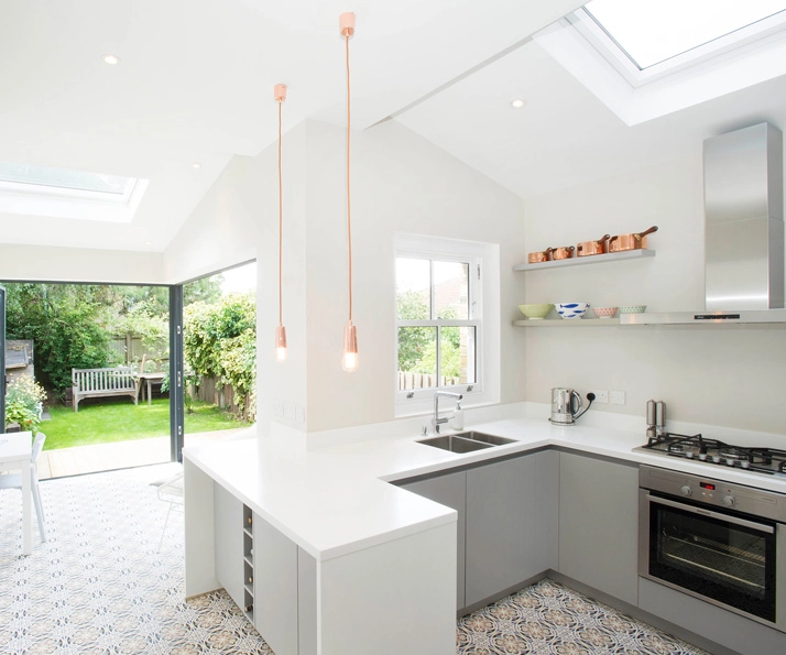 A grey and white German kitchen in a side return extension in London